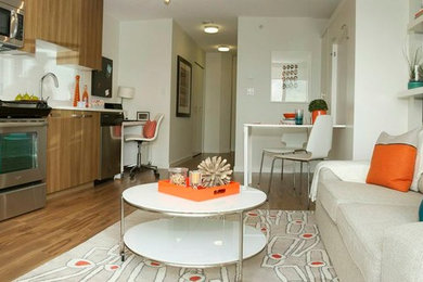 Example of a small trendy open concept medium tone wood floor living room design in Vancouver with white walls