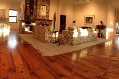 Inspiration for a mid-sized timeless formal and open concept medium tone wood floor living room remodel in Albuquerque with beige walls, a corner fireplace, a wood fireplace surround and no tv