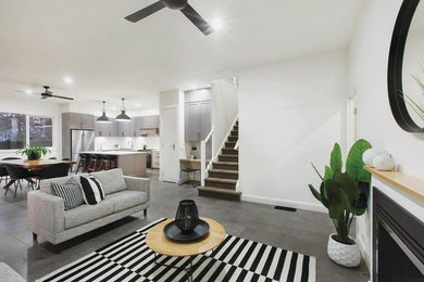 Cette photo montre un salon moderne ouvert avec un mur blanc, un sol en carrelage de porcelaine et un sol gris.
