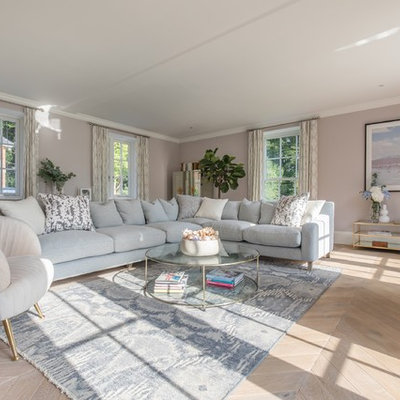 Inspiration for a mid-sized transitional enclosed light wood floor and beige floor living room remodel in Dorset with pink walls