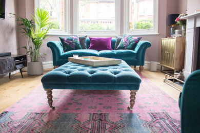 Mittelgroßes, Abgetrenntes Eklektisches Wohnzimmer mit Hausbar, rosa Wandfarbe, Laminat, Kamin, Kaminumrandung aus Stein und TV-Wand in London
