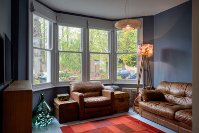 ロンドンにある中くらいなトランジショナルスタイルのおしゃれなリビング (ライブラリー、青い壁、塗装フローリング、白い床) の写真