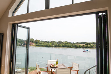 View of high-level window, bi-folding doors and balcony from living room