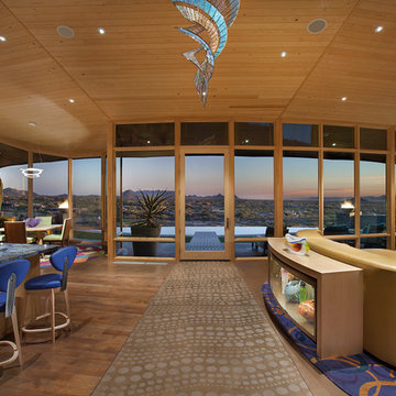 View over pool from contemporary great room with wood ceilings