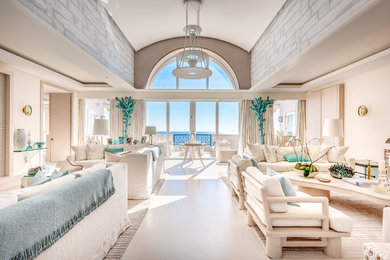 Идея дизайна: огромная изолированная гостиная комната в морском стиле с белыми стенами, бетонным полом, стандартным камином, фасадом камина из камня, скрытым телевизором и белым полом