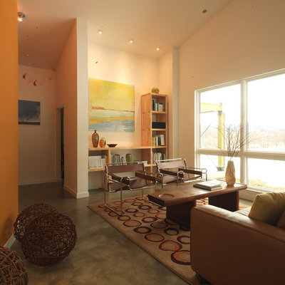 Example of a large farmhouse enclosed concrete floor living room library design in Burlington with orange walls