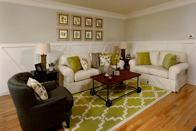 Immagine di un soggiorno chic con pareti grigie e parquet chiaro