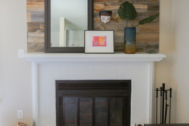 Foto de salón abierto actual pequeño con paredes grises, suelo vinílico, todas las chimeneas, marco de chimenea de madera, televisor colgado en la pared y suelo blanco