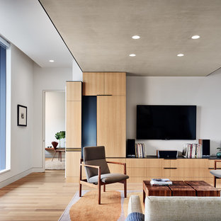Trendy formal and open concept light wood floor and beige floor living room photo in Austin with gray walls and a wall-mounted tv
