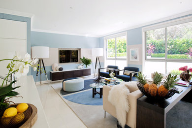 Cette image montre un salon design de taille moyenne et ouvert avec un sol blanc, un mur bleu, aucune cheminée et un téléviseur fixé au mur.
