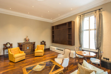 Großes, Repräsentatives Modernes Wohnzimmer mit beiger Wandfarbe, dunklem Holzboden, Gaskamin, gefliester Kaminumrandung und verstecktem TV in London