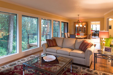 Cette photo montre un salon tendance de taille moyenne avec un mur jaune, un sol en bois brun et une cheminée standard.