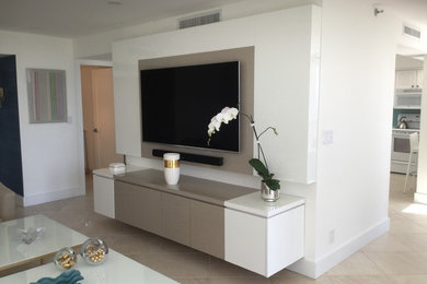 Imagen de salón abierto minimalista grande sin chimenea con paredes blancas, televisor colgado en la pared y suelo beige