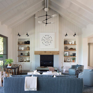 Immagine di un soggiorno country aperto con pareti bianche, parquet scuro, camino classico, pavimento marrone, soffitto a volta e pareti in perlinato