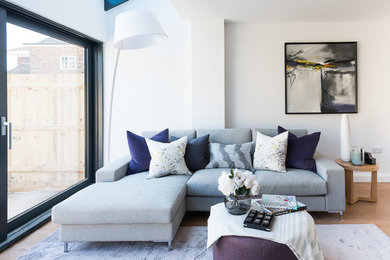 Photo of a medium sized traditional enclosed living room in London with white walls, light hardwood flooring and beige floors.