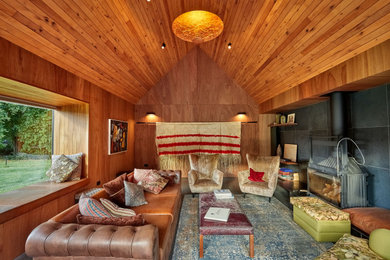 Imagen de salón abierto y abovedado contemporáneo de tamaño medio con paredes marrones, estufa de leña, madera y madera