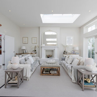 Photo of a nautical formal enclosed living room in London with white walls, a standard fireplace and white floors.