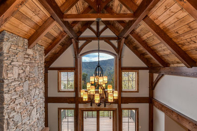 Mountain style medium tone wood floor living room photo in Other with a standard fireplace and a stone fireplace