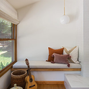 Mittelgroßes, Repräsentatives, Fernseherloses, Offenes Nordisches Wohnzimmer mit weißer Wandfarbe, Bambusparkett, Kamin, gefliester Kaminumrandung und gelbem Boden in Los Angeles