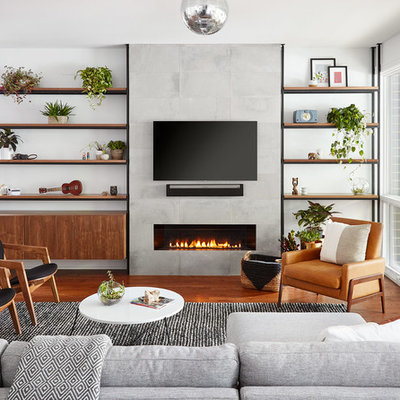 Example of a trendy medium tone wood floor and brown floor living room design in Chicago with white walls, a ribbon fireplace, a tile fireplace and a wall-mounted tv
