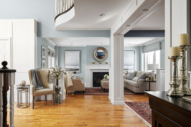 Mittelgroßes, Repräsentatives, Fernseherloses, Offenes Klassisches Wohnzimmer mit blauer Wandfarbe, hellem Holzboden, Kamin, verputzter Kaminumrandung und braunem Boden in Toronto