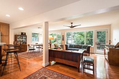Example of a mid-sized arts and crafts open concept light wood floor and brown floor living room design in Baltimore with white walls