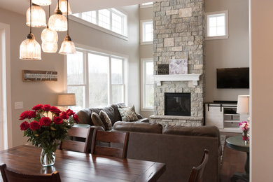 Living room - large transitional formal and open concept medium tone wood floor living room idea in Milwaukee with gray walls, a standard fireplace, a stone fireplace and a wall-mounted tv