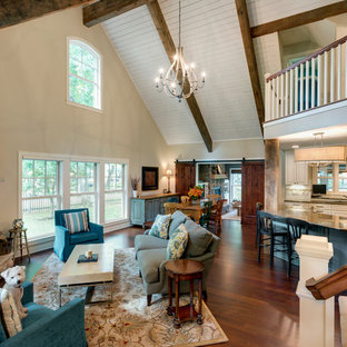 Immagine di un ampio soggiorno stile shabby aperto con sala formale, pareti beige, parquet scuro, camino classico, cornice del camino in pietra, TV a parete e pavimento marrone