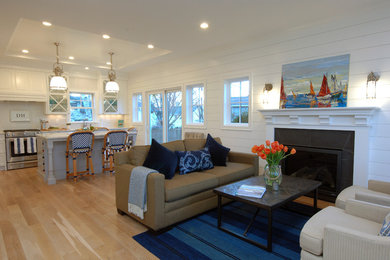 Photo of a nautical open plan living room in Minneapolis with white walls, light hardwood flooring, a standard fireplace, a stone fireplace surround and brown floors.