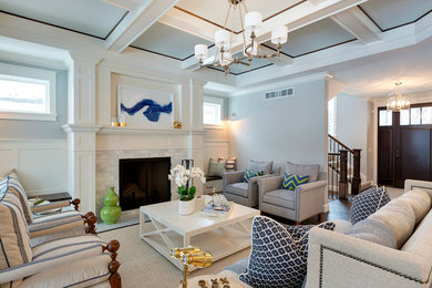На фото: гостиная комната в стиле неоклассика (современная классика) с серыми стенами и стандартным камином с