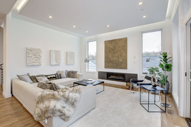 Diseño de salón para visitas abierto actual con marco de chimenea de metal, televisor retractable, suelo beige y panelado