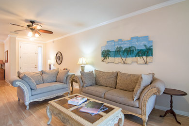 Repräsentatives, Offenes Wohnzimmer mit beiger Wandfarbe, hellem Holzboden und freistehendem TV in Jacksonville
