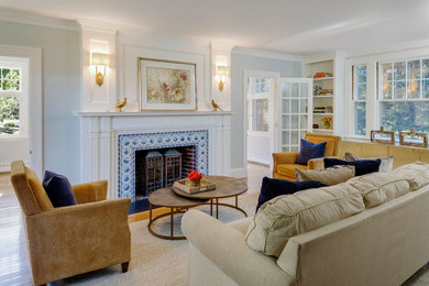 Example of a classic enclosed medium tone wood floor and brown floor living room design in Boston with gray walls, a standard fireplace and a tile fireplace