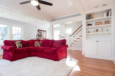 Large transitional open concept light wood floor and brown floor living room photo in Boston with gray walls