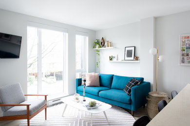 Living room - small modern open concept medium tone wood floor and gray floor living room idea in Vancouver with white walls and a wall-mounted tv