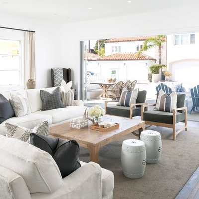 Living room - coastal medium tone wood floor living room idea in Orange County with white walls and a standard fireplace