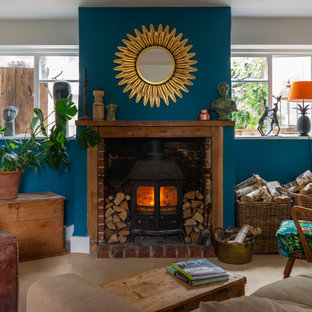 Inspiration for an eclectic living room in London with blue walls, a wood burning stove, no tv and beige floors.