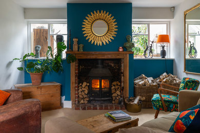 Fernseherloses Eklektisches Wohnzimmer mit blauer Wandfarbe, Kaminofen und beigem Boden in London