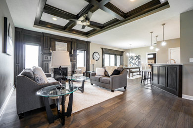 Inspiration for a transitional open concept medium tone wood floor, brown floor, tray ceiling and wainscoting living room remodel in Other with gray walls, a standard fireplace and a stone fireplace