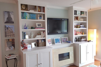 Kleines Eklektisches Wohnzimmer mit blauer Wandfarbe, hellem Holzboden, Hängekamin, Kaminumrandung aus Stein und TV-Wand in Bridgeport