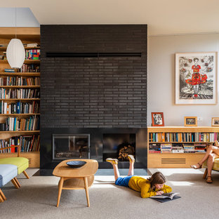 Inspiration for a midcentury living room in Hobart with white walls, carpet, a standard fireplace, a brick fireplace surround and beige floor.