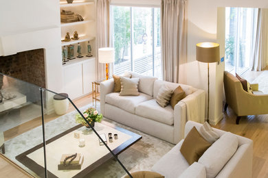 Mittelgroßes, Offenes Modernes Wohnzimmer mit weißer Wandfarbe, hellem Holzboden, Kamin und verputzter Kaminumrandung in London