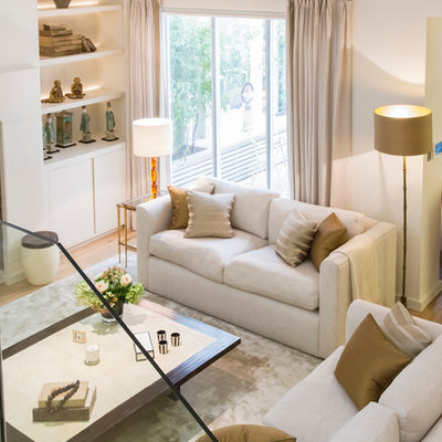Inspiration for a mid-sized contemporary open concept light wood floor living room remodel in London with white walls, a standard fireplace and a plaster fireplace
