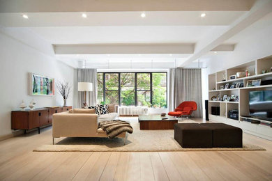 Living room - contemporary loft-style light wood floor living room idea in New York with white walls, no fireplace and a media wall