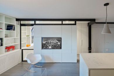 Foto de salón abierto minimalista pequeño con paredes blancas, suelo de madera clara, pared multimedia y suelo gris