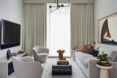 Immagine di un soggiorno minimal di medie dimensioni e aperto con pareti bianche, parquet chiaro, nessun camino, TV a parete e pavimento beige