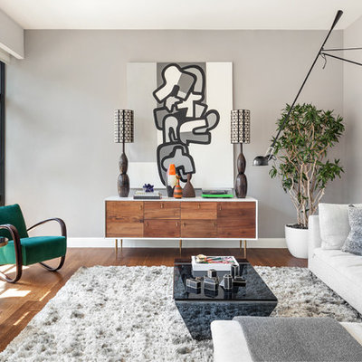 Living room - large contemporary open concept medium tone wood floor living room idea in New York with gray walls and no fireplace