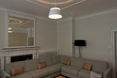 Idee per un soggiorno minimal di medie dimensioni e chiuso con sala formale, pareti bianche, pavimento in legno massello medio, camino classico e nessuna TV