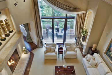 Modelo de salón clásico con paredes beige, todas las chimeneas, suelo beige y cortinas