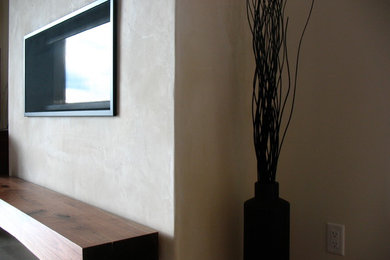 Foto di un soggiorno con pareti bianche e cornice del camino in intonaco